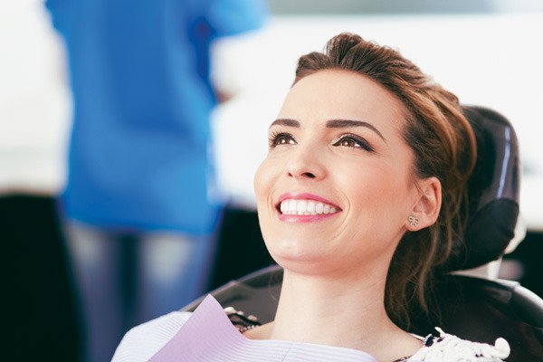A woman smiles in a dental chair, possibly after single tooth anesthesia in Dresher, PA